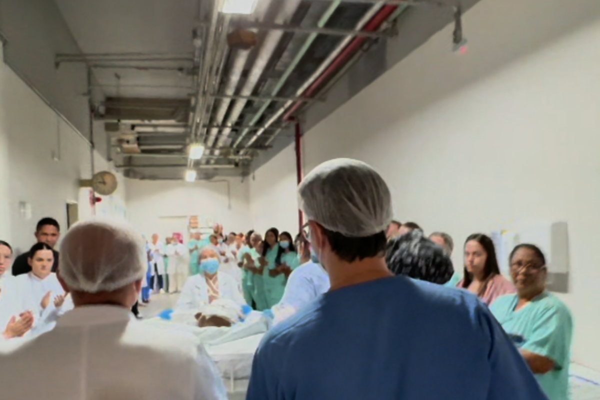 Homem foi homenageado em um corredor de palmas, formado por profissionais de saúde e familiares
